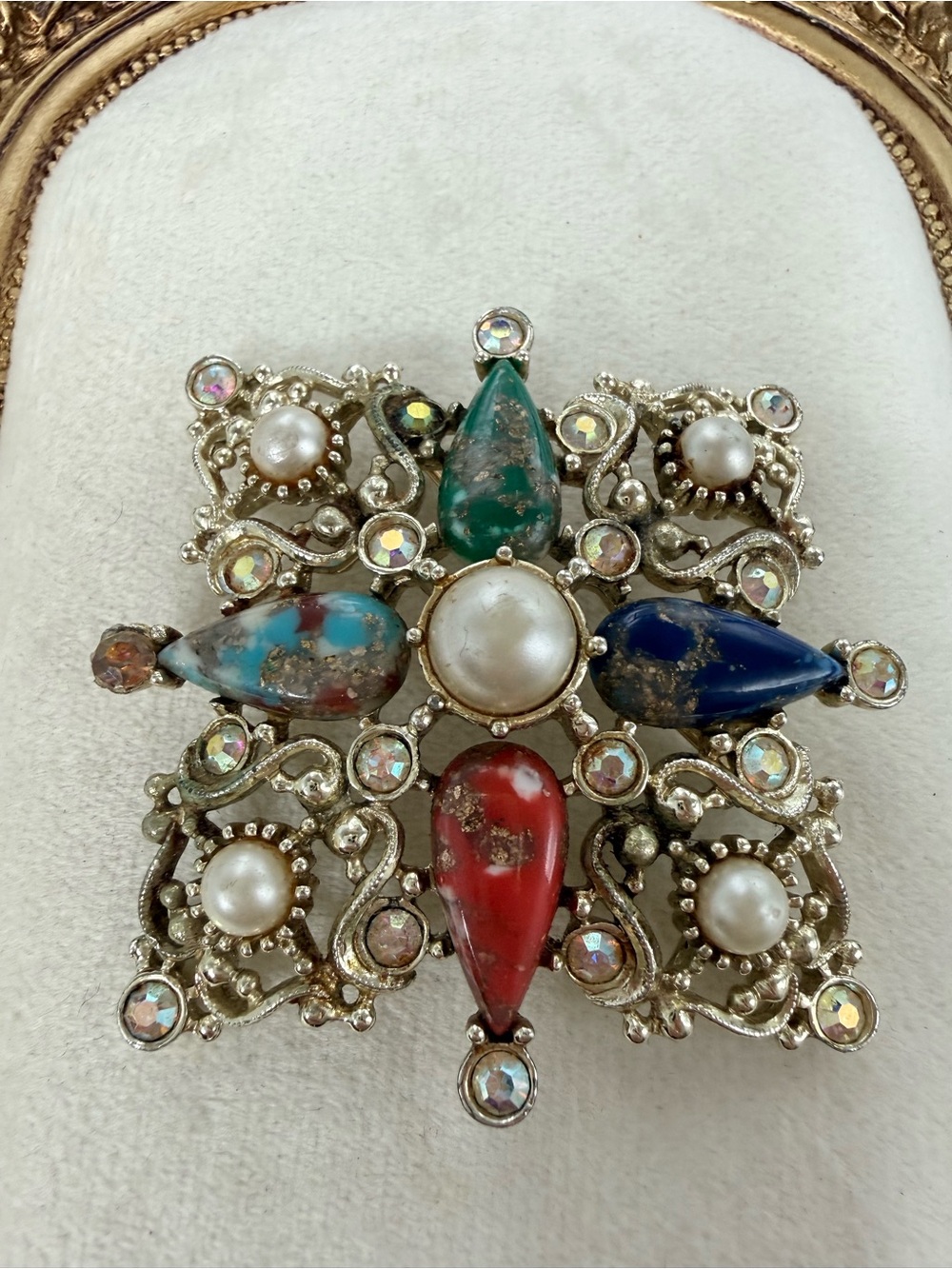 vintage Sarah Coventry Maltese cross brooch featuring multicolored art glass AB